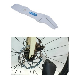 Outil pour frein à disque combinant deux fonctions différentes pour garantir que les rotors de frein peuvent tourner librement et silencieusement dans l'étrier. À une extrémité se trouve une clé de correction de rotor, avec deux fentes de longueurs différentes qui permettent d'appliquer des niveaux différents de levier au rotor pour le redresser. L'autre extrémité comporte l'outil de compression de pistons de frein, utilisé pour repousser doucement les plaquettes et les pistons dans l'étrier lors du remplacement ou du réglage des plaquettes de frein.

Outil pour frein 2-en-1 combinant une clé de correction de rotor et un outil de compression de piston de frein.
Extrémité fendue utilisée pour redresser un rotor de frein déformé ou endommagé.
Extrémité biseautée utilisée pour séparer les plaquettes de frein et compresser les pistons.
En chrome-molybdène